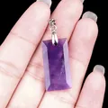 Colgante rectangular de amatista natural con cierre plateado sostenido en la mano - Amatista