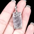 Colgante rectangular de amatista natural facetada con enganche plateado sobre la mano - Labradorita