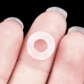 Pale pink translucent natural agate stone hollow circular bead held on fingertip - 10mm / Rose Quartz
