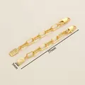 Detail of 18K gold-plated paperclip extender chain with Queen Elizabeth and gold bar charms - 5x77mm
