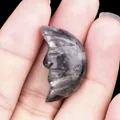 Crescent moon hand-carved labradorite stone with blue-purple flash and moon face relief - Larvikite