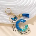 Portachiavi con lettera C in resina blu con paillettes, nappa e farfalla, altezza 42mm - Blu C