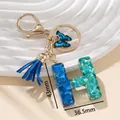 Portachiavi lettera H in resina glitterata blu con farfalla e nappa in pelle - Blu H