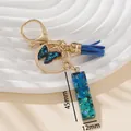 Portachiavi con farfalla blu con resina glitterata, clip dorata e nappina blu - Blu I