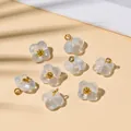 Macro shot of 8 translucent frosted flower pendants with gold core for DIY jewelry making - 10x10mm / Pearlescent Light Blue