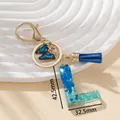 Portachiavi lettera L in resina blu con paillettes, farfalla e nappa per signora - Blu L