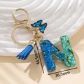 Portachiavi lettera N in resina blu con glitter, nappine e ciondolo farfalla - Blu N