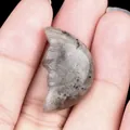 Carved labradorite moon stone with face detail held in hand for scale and texture - Labradorite