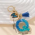 Portachiavi lettera Q in resina blu con paillettes, farfalla e nappa coordinata - Blu Q