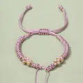 Detailaufnahme von handgewebtem Armband in Pink und Gold mit verstellbarem Schiebeknoten - Rosa