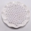 Close-up van witte ronde parels met centrale gaten in een decoratieve keramische schaal - 3mm (400 Stuks/Pak) / Wit