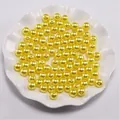 Macro-detail van heldergele ABS-imitatieparels met gaten voor doe-het-zelf sieraden - Geel