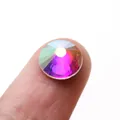 Macro shot of Aurora AB crystal rhinestone with multiple facets on finger for DIY nail art - SS3 Size (1440 Pieces/Pack) / Flatback AB Color