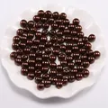 Macro-opname van donkerbruine ABS-parels met gladde afwerking en centrale doorboring - koffiekleur