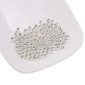 Close-up van gepolijste zilveren ijzeren kralen voor DIY sieraden maken in een wit bakje - 2mm (500 stuks/verpakking) / Zilver