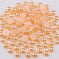 Close-up of champagne flatback half round pearls for DIY jewelry and nail art - Orange