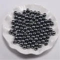 Macro-opname van donkergrijze metalen ABS imitatierparels met gaten in een witte schaal - Zilverijs