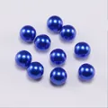 Macro shot of dark blue round ABS faux pearls for DIY jewelry making and crafts - Blue