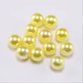 Close-up of smooth lemon yellow ABS imitation pearls with glossy finish for DIY jewelry - Yellow
