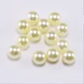 Macro shot of smooth cream-colored ABS imitation pearls with glossy finish for DIY jewelry - Light Yellow