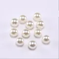 Macro shot of smooth cream white round ABS faux pearls with glossy finish for DIY jewelry - Off White