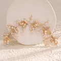 Golden bridal hair set with alloy leaves and delicate pearls on white styling base - Gold