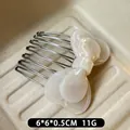 Creamy white acetate bow hair comb with elegant pearl finish and silver metal teeth - Pearl White