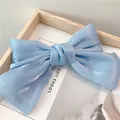 Dettaglio del fiocco in raso azzurro perlato su cornice in legno minimalista - Zircone Blu Chiaro