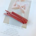 Detail of dark red plastic hair root clip with comb teeth design for volume styling - Red