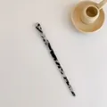 Minimalistische acetaat haarspeld met marmerpatroon en elegant gedraaid ontwerp - Koemotief