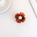 Elegante molletta a fiore ambra con perla centrale e bordo a spirale dorata - Ambra