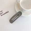 Fermaglio per capelli opaco grigio-nero oversize rettangolare su un tavolo bianco - Stile Grigio