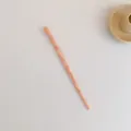 Detail van een lichtroze marmeren acetaat haarspeld met uniek gedraaid ontwerp - Roze