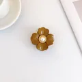 Ingwergelbe Blumen-Haarklammer mit zentraler Perle und goldenem gedrehtem Rand - Braun