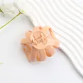 Matte apricot octopus hair claw clip with multi-prong design on white wave texture - Glossy Korean Pink