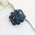 Matte navy blue octopus hair claw clip with multi-tooth design on a white decorative plate - Matte Navy Blue