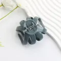 Matte grey-green octopus hair claw clip in durable PC material on a wavy white display board - Glossy Deep Blue