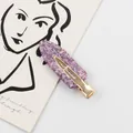 Paarse glitter haarspeld met gouden snavelklem op een minimalistische kaartachtergrond - Paars