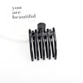 Grande pince à cheveux noire brillante avec structure à 5 dents sur plateau blanc - Noir Brillant