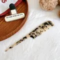 Close-up of tortoise shell pattern acetate hair comb with pointed tail for styling - Light Tortoiseshell