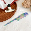 Macro shot of colorful marble pattern acetate tail comb for hairstyling and sectioning - Blue