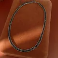 Nahaufnahme einer eleganten schwarzen Strass-Halskette auf einem braunen Schmuckpad. - Gunmetal