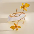 Elegante gouden metalen armband voor de bovenarm met gele emaille bloemen - Emaille Bloem Stijl / Goud & Geel