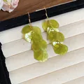 Dettaglio degli orecchini a nappa in conchiglia verde chiaro con trama iridescente - Stile 20