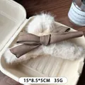 Beige Plüsch-Haarklammer mit dunkelbrauner Satinschleife für winterliche Frisuren - Cremeweiß