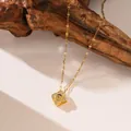 Primo piano dettagliato di una collana proiezione quadrifoglio oro con pietre di zircone su legno - Stile Quadrifoglio (9088) / Oro