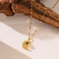 Primo piano della collana con proiezione luna dorata e cristalli su sfondo legno - Stile Luna (9085) / Oro