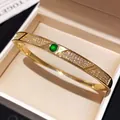 Bracciale rigido dorato con pavé di zirconi e una gemma verde posta al centro - Oro-Verde