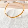 Detalle de la diadema fina ámbar con dientes antideslizantes sobre fondo blanco - Amarillo
