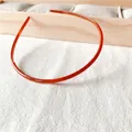 Detail of amber orange slim headband with anti-slip inner teeth on linen fabric - Orange